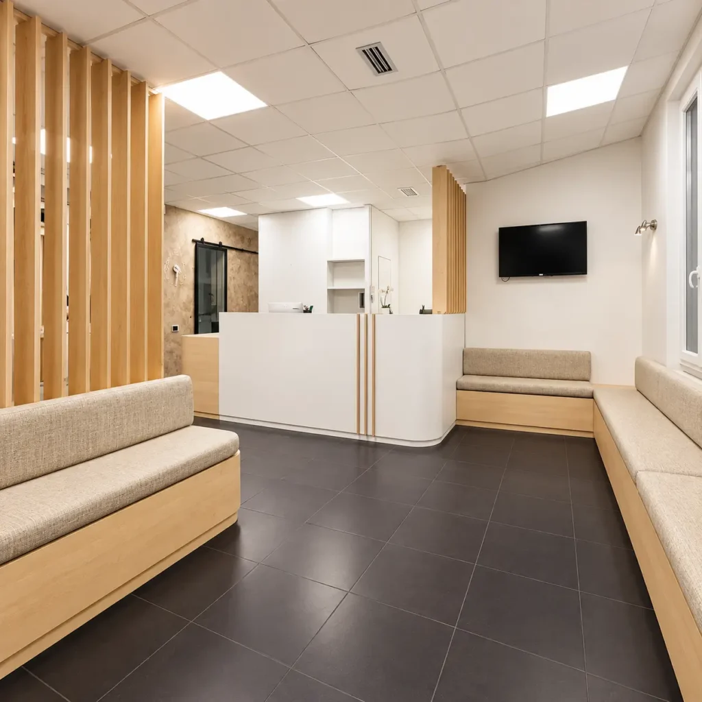 Banque d'accueil sur-mesure avec claustra en bois et banquettes de salle d'attente créées pour un cabinet médical dans le Var.