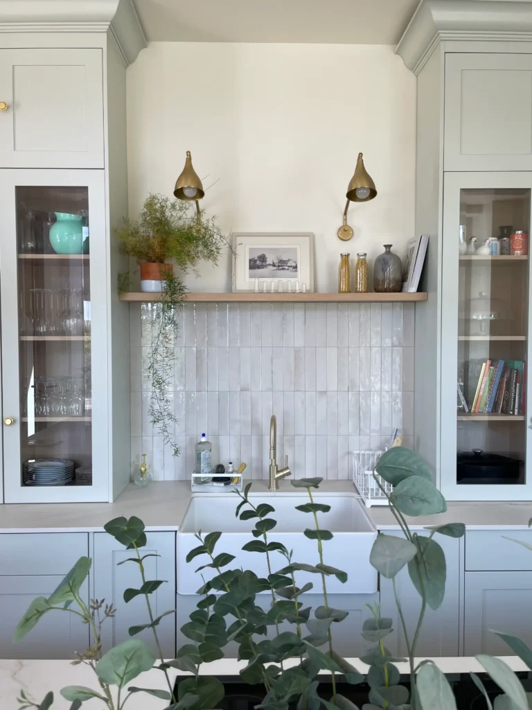Meuble de cuisine sur-mesure avec vitrines encadrées, évier timbre d'office et détails en laiton dans le Var.